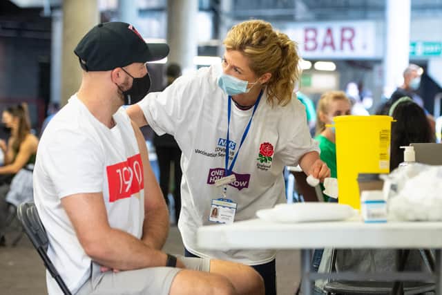 A man receives a vaccine at Twickenham rugby stadium in London on Monday, as a walk-in vaccination centre administered 15,000 doses to over 18s in the local area.