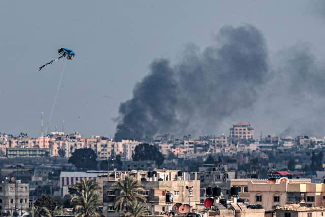 A kite is flown in Rafah as smoke billows following Israeli bombardment on Khan Yunis in the southern Gaza Strip on Tuesday amid continuing battles between Israel and  Hamas. PIC: (Photo by SAID KHATIB/AFP via Getty Images)