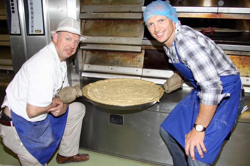England rugby star Matt Dawson (right) and baker Trevor Jackson remove a giant Bakewell pudding from the oven at Jacksons the Baker in 2010. the pudding from the oven.
