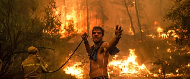 A man appeals for help as the water runs out while he fights a forest fire on the island of Evia, Greece (Picture: Angelos Tzortzinis/AFP via Getty Images)