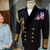 Kate Braun, curator at the National Museum of the Royal Navy, looks at a naval uniform which once belonged to the Duke of Edinburgh