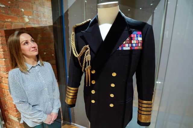 Kate Braun, curator at the National Museum of the Royal Navy, looks at a naval uniform which once belonged to the Duke of Edinburgh