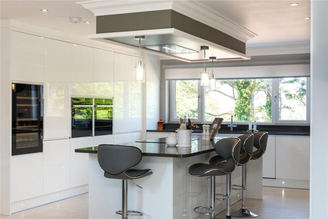 Kitchen with integrated appliances, including two ovens, wine fridge and seamless stone worktops.