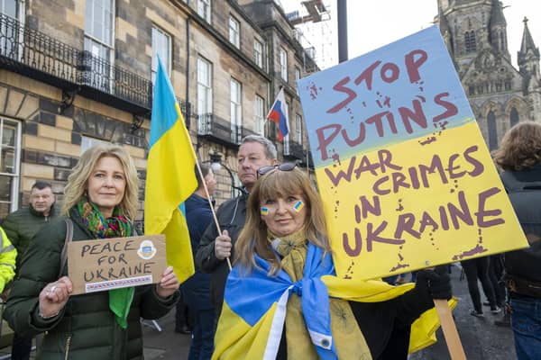 A protest against Vladimir Putin's invasion of Ukraine outside the Russian consulate in Edinburgh. The Russian flag can be seen in the background (Picture: Lesley Martin/PA)