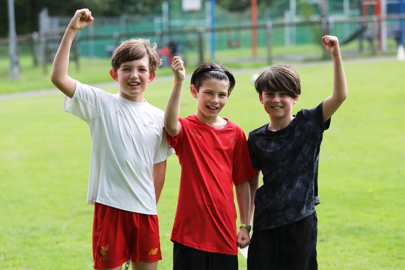 Three junior parkrunners raise a hand for the camera. Picture: Sam Stephenson