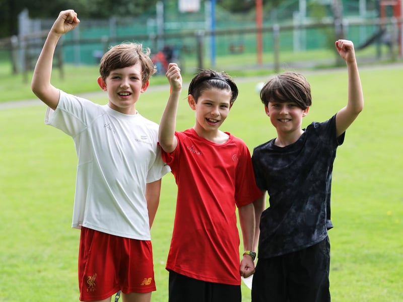 Three junior parkrunners raise a hand for the camera. Picture: Sam Stephenson