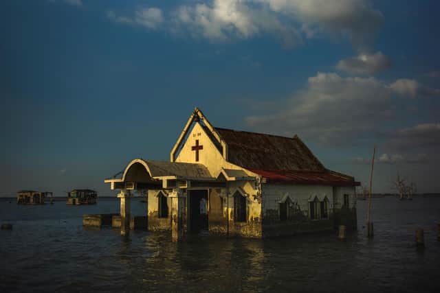 Sea water surrounds the church of Pariahan village, north of Philippines' capital Manila. Since tropical cyclone Nesat hit the country in 2011, the village has remained submerged in sea water and is being slowly washed away (Picture: Jes Aznar/Getty Images)