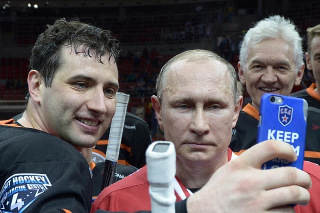 An ice hockey player takes a selfie with Vladimir Putin, watched by Gennady Timchenko, who has close ties to Novatek, a private Russian firm part owned by TotalEnergies (Picture: Alexei Nikolsky/RIA-Novosti/AFP via Getty Images)