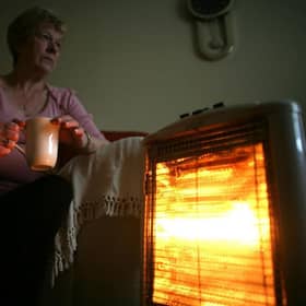 An old age pensioner keeps warm with the aid of an electric heater - far fewer pensioners will be eligible for the winter fuel payment this year  (Photo by Christopher Furlong/Getty Images)