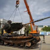 Ukrainian soldiers unload a destroyed Russian tank to install it as a symbol of war in central Kyiv. Picture: AP Photo/Efrem Lukatsky