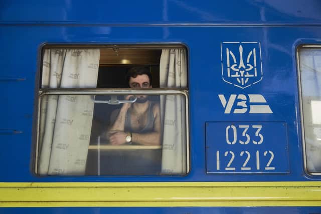 A man on the phone on an evacuation train driving to the west of Ukraine on Saturday. The UK has pledged more arms for Ukraine as explosions and gunfire were reported around Kyiv . PIC: Pierre Crom/Getty Images.