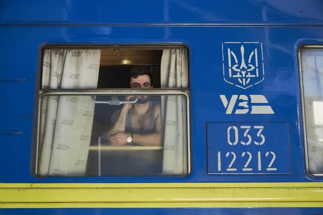A man on the phone on an evacuation train driving to the west of Ukraine on Saturday. The UK has pledged more arms for Ukraine as explosions and gunfire were reported around Kyiv . PIC:  Pierre Crom/Getty Images.
