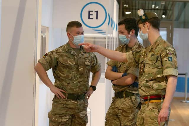 Military personel gesture at a temporary Covid-19 vaccination centre set up at the Royal Highland Showground near Edinburgh, Scotland, on February 4, 2021. Photo by Andrew Milligan via Getty Images