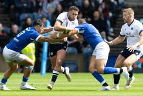 Scotland's Ollie Smith (centre) is challenged during The Famous Grouse Nations Series match between Scotland and Italy at the Scottish Gas Murrayfield Stadium, on July 29, 2023, in Edinburgh, Scotland.  (Photo by Ross Parker / SNS Group)