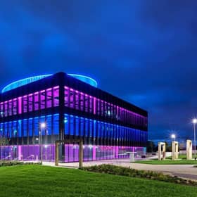 A view of the Halo HQ building in Kilmarnock lit up at night.