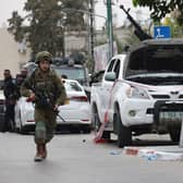 An Israeli soldier stands guard next to a pickup truck mounted with machine gun in the southern city of Sderot after the Palestinian militant group Hamas launched a large-scale surprise attack on Israel. (Photo by Oren ZIV / AFP) (Photo by OREN ZIV/AFP via Getty Images)