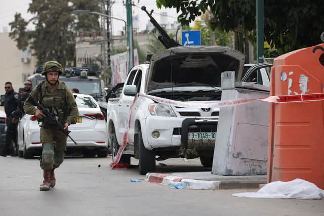 An Israeli soldier stands guard next to a pickup truck mounted with machine gun in the southern city of Sderot after the Palestinian militant group Hamas launched a large-scale surprise attack on Israel. (Photo by Oren ZIV / AFP) (Photo by OREN ZIV/AFP via Getty Images)