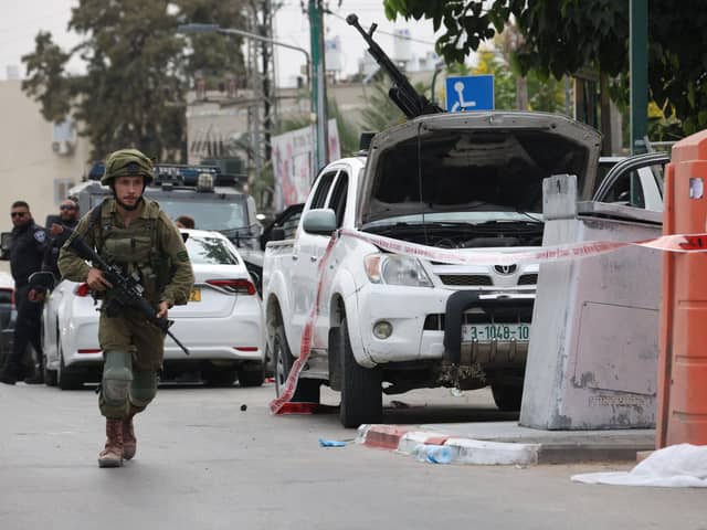 An Israeli soldier stands guard next to a pickup truck mounted with machine gun in the southern city of Sderot after the Palestinian militant group Hamas launched a large-scale surprise attack on Israel. (Photo by Oren ZIV / AFP) (Photo by OREN ZIV/AFP via Getty Images)