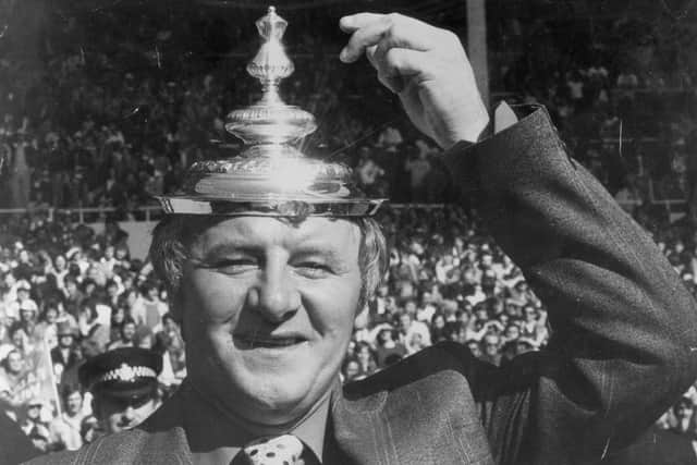 Docherty tips his makeshift hat - the FA Cup lid - to his exciting Manchester United after their 1977 Wembley triumph.