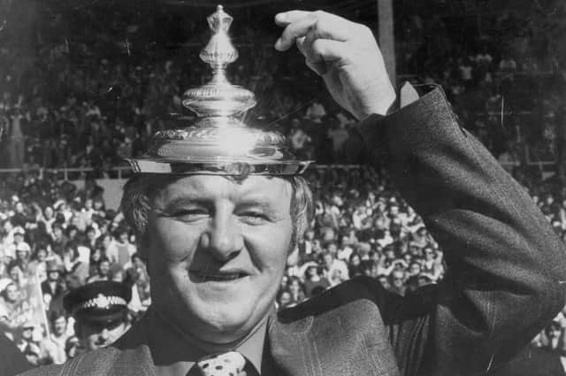 Docherty tips his makeshift hat - the FA Cup lid - to his exciting Manchester United after their 1977 Wembley triumph.