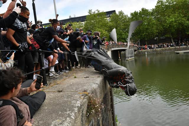Protesters throw a statue of slave trader Edward Colston into Bristol harbour during a Black Lives Matter rally (Picture: Ben Birchall/PA)