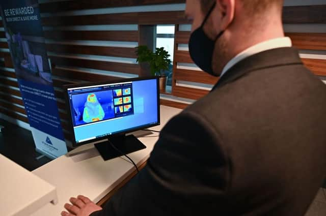 A staff member looks at a thermal image of a guest in a quarantine hotel