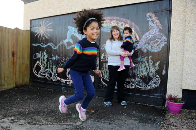 Larbert mum Christine Hilditch, a community artist, and five-year-old daughter Eilidh have been producing a series of colourful drawing to brighten up the day for passers-by - with a little help from baby sister Isla. Picture: Michael Gillen.