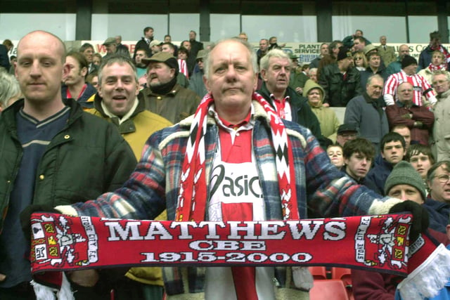A Stoke fan holds aloft a scarf.