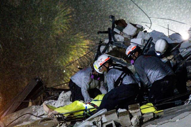 Rescue crews picked through tons of rubble on Thursday looking for survivors after the collapse of part of an oceanfront apartment tower overnight near Miami, where officials reported at least one person dead and nearly 100 missing.
