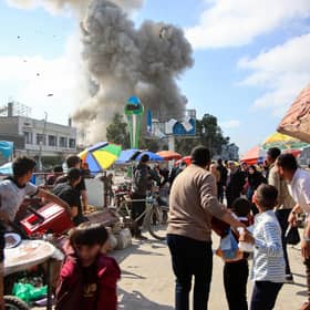 Palestinians look at smoke billowing during Israeli bombardment on the Firas market area in Gaza City on Friday. Picture: AFP via Getty Images