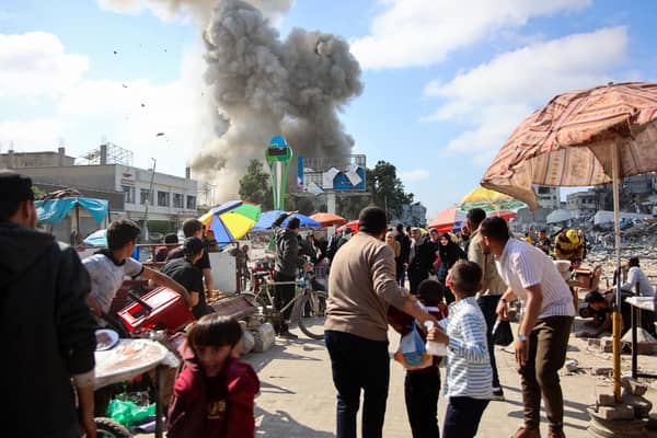 Palestinians look at smoke billowing during Israeli bombardment on the Firas market area in Gaza City on Friday. Picture: AFP via Getty Images