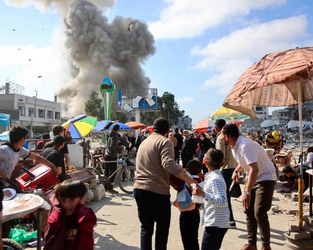 Palestinians look at smoke billowing during Israeli bombardment on the Firas market area in Gaza City on Friday. Picture: AFP via Getty Images