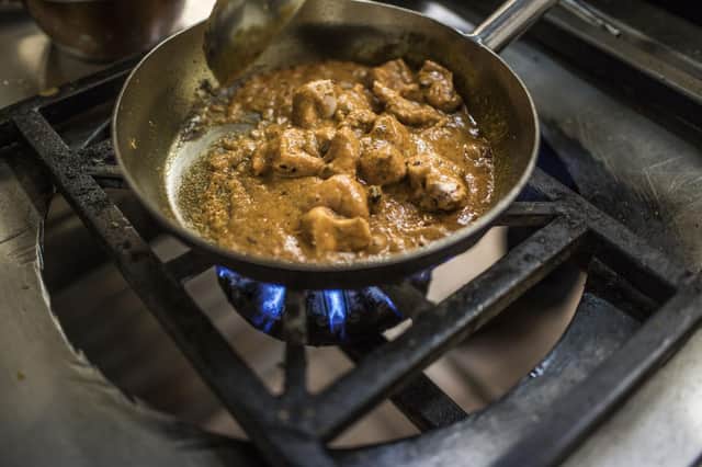 A butter chicken dish cooks in the pan, but should it be described as a 'curry'? (Picture: Gulshan Khan/AFP via Getty Images)