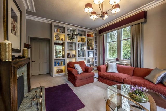The corner aspect sitting room has an open fireplace and twin aspect windows.