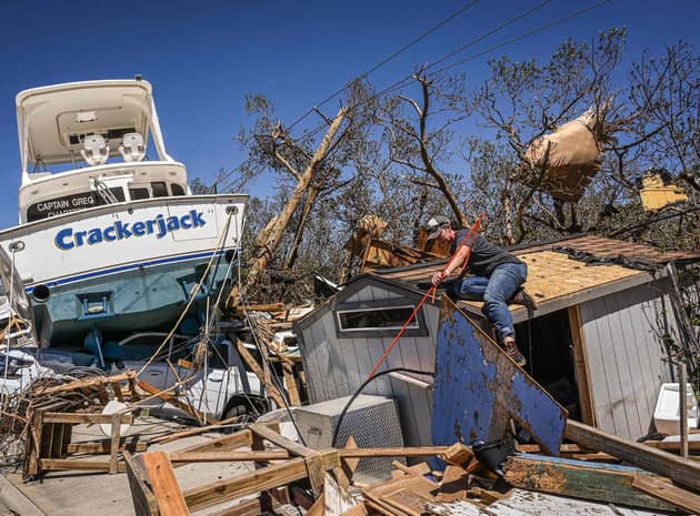 People clear debris in the aftermath of Hurricane Ian in Fort Myers Beach, Florida. Picture: Giogio Viera/AFP via Getty Images
