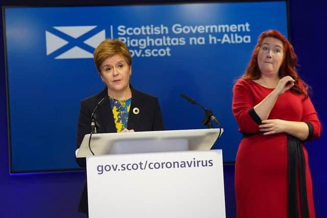 Nicola Sturgeon in front of the ditched inverted Saltire logo.