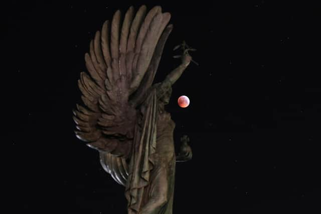 A super blood wolf moon over the peace statue on Brighton seafront during a lunar eclipse.