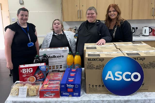 Kim Alexander (left), of ASCO, presents the company's donations for the Tuesday group to Stephanie, Marissa and Kirsty.