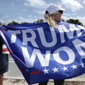 A supporter of former US President Donald Trump holds a flag repeating his false claim about the 2020 presidential election near his home in Mar-a-Lago, Florida (Picture: Alex Wong/Getty Images)