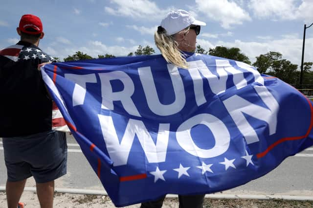 A supporter of former US President Donald Trump holds a flag repeating his false claim about the 2020 presidential election near his home in Mar-a-Lago, Florida (Picture: Alex Wong/Getty Images)