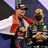 2021 FIA Formula One World Champion Red Bull's Dutch driver Max Verstappen walks past second-placed Mercedes' British driver Lewis Hamilton.