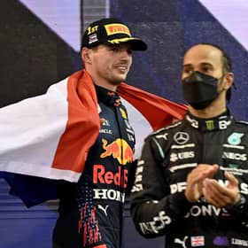 2021 FIA Formula One World Champion Red Bull's Dutch driver Max Verstappen walks past second-placed Mercedes' British driver Lewis Hamilton.