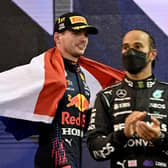 2021 FIA Formula One World Champion Red Bull's Dutch driver Max Verstappen walks past second-placed Mercedes' British driver Lewis Hamilton.