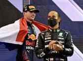 2021 FIA Formula One World Champion Red Bull's Dutch driver Max Verstappen walks past second-placed Mercedes' British driver Lewis Hamilton.