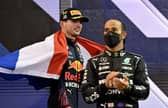 2021 FIA Formula One World Champion Red Bull's Dutch driver Max Verstappen walks past second-placed Mercedes' British driver Lewis Hamilton.