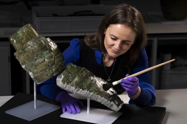 Undated handout photo issued by National Museums Scotland of conservator Bethan Bryan with an "incredibly rare" piece of Roman armour from the second century which has been reconstructed from dozens of fragments. Photo: Duncan McGlynn/National Museums Scotland/PA Wire