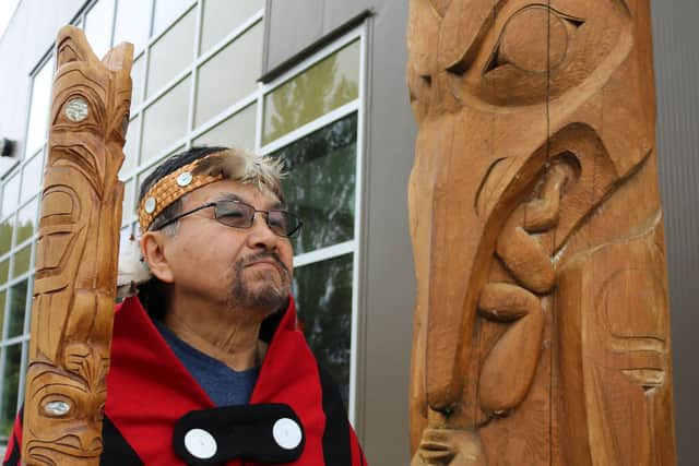 Sim’oogit Ni’isjoohl (Chief Earl Stephens) stands next to a replica of the Ni'isjoohl memorial pole in the Nisga'a Village of Laxgalts’ap in British Columbia, Canada.