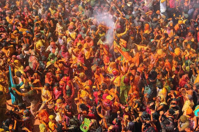 People smeared with colour powder, known as Gulal, celebrate Holi, the spring festival of colours, at Priyakant Ju Temple in Vrindavan. Photo: AFP via Getty Images.