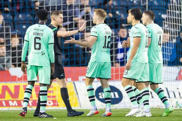 Referee David Dickinson is surrounded by Hibs players after awarding Kilmarnock a penalty.