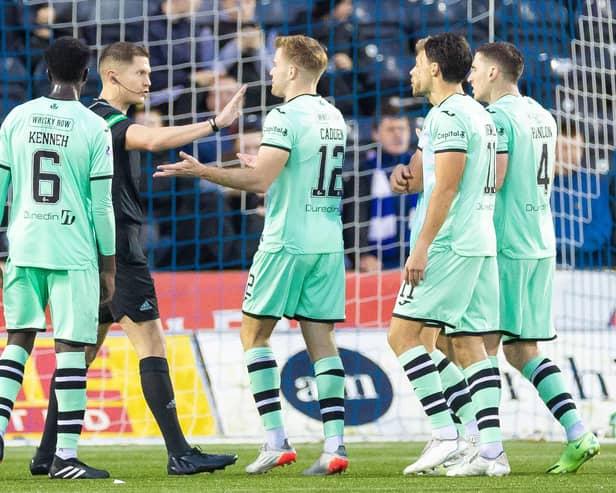 Referee David Dickinson is surrounded by Hibs players after awarding Kilmarnock a penalty.